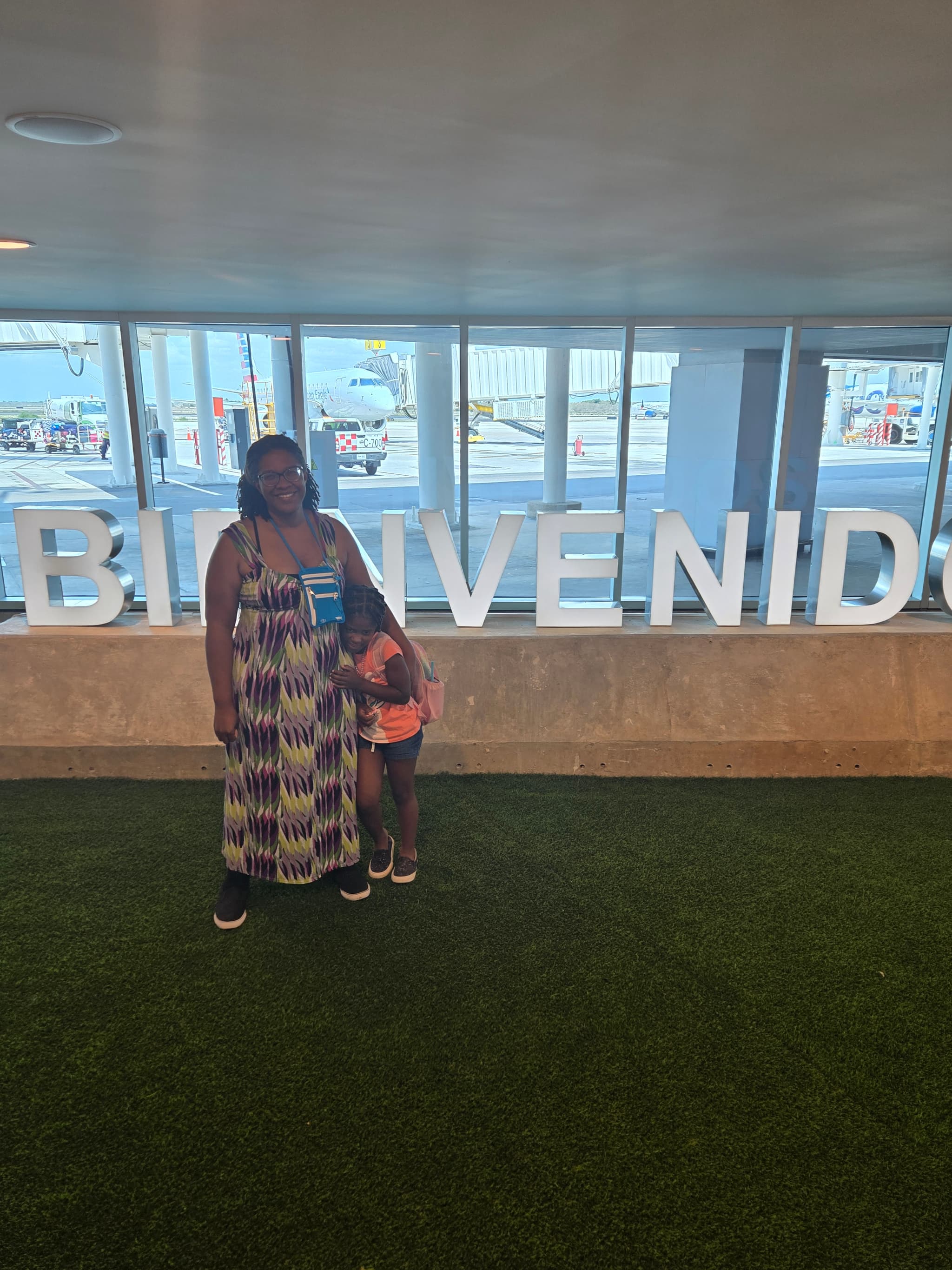 Izzy and I standing in front of a bienvendos sign